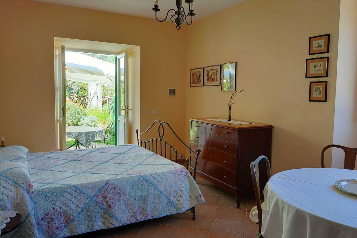 Un dormitorio con cama, cómoda, silla, mesa y candelabro.