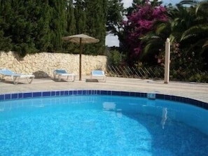Utomhuspool, parasoller och solstolar