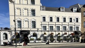 Tyylikäs rakennus, jossa on huomiota herättävä sisäänkäynti, kyltti, jossa lukee »King’s Cross Inn Hotel», ja katukyltti, jossa lukee »Crestfield Street».
