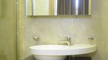 Ein Badezimmer mit Waschbecken, Spiegel und Dusche.