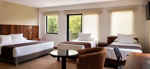 Una habitación de hotel con dos camas, una mesita redonda y una silla.