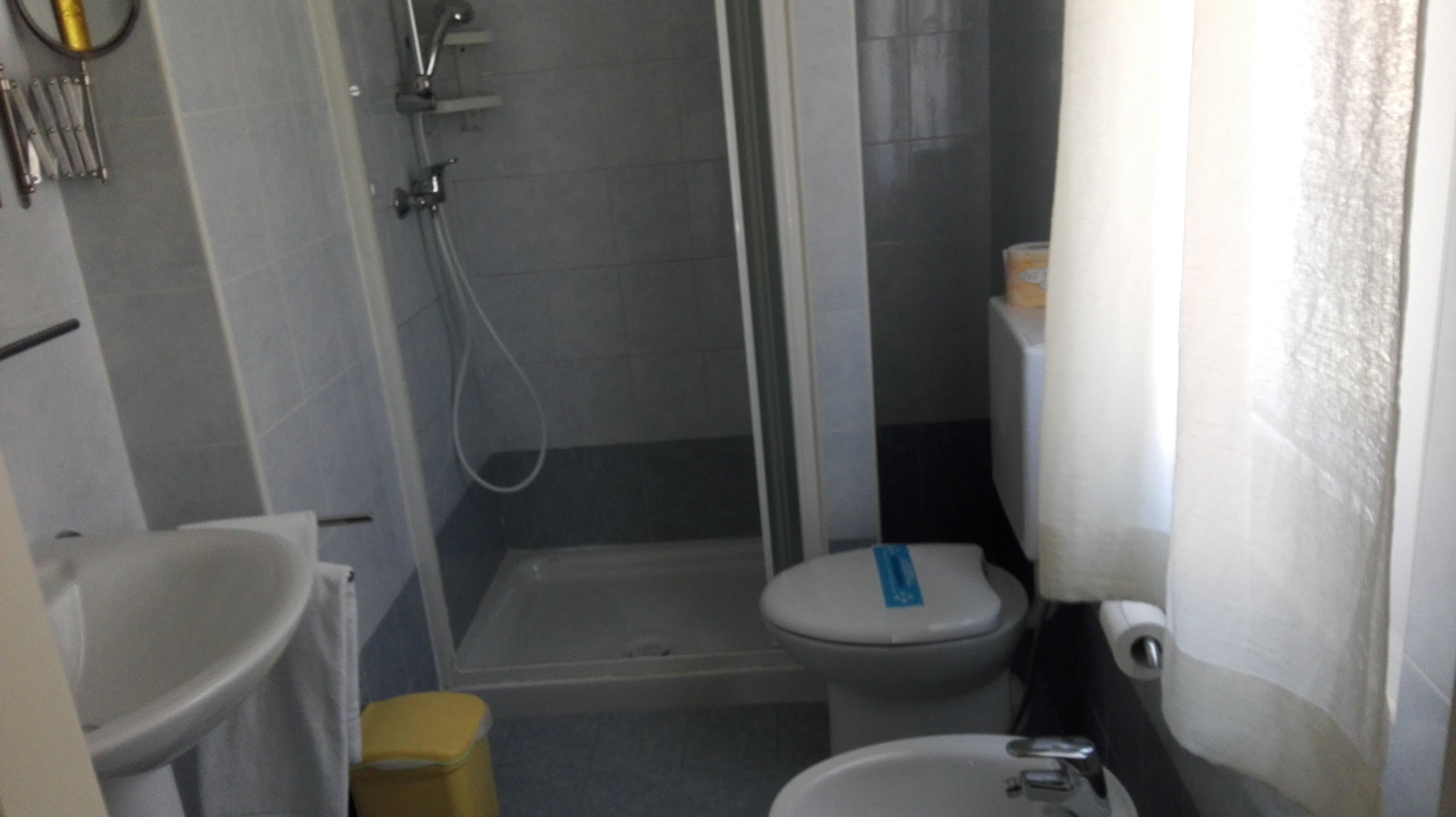 Un baño pequeño con inodoro, lavabo y ducha.