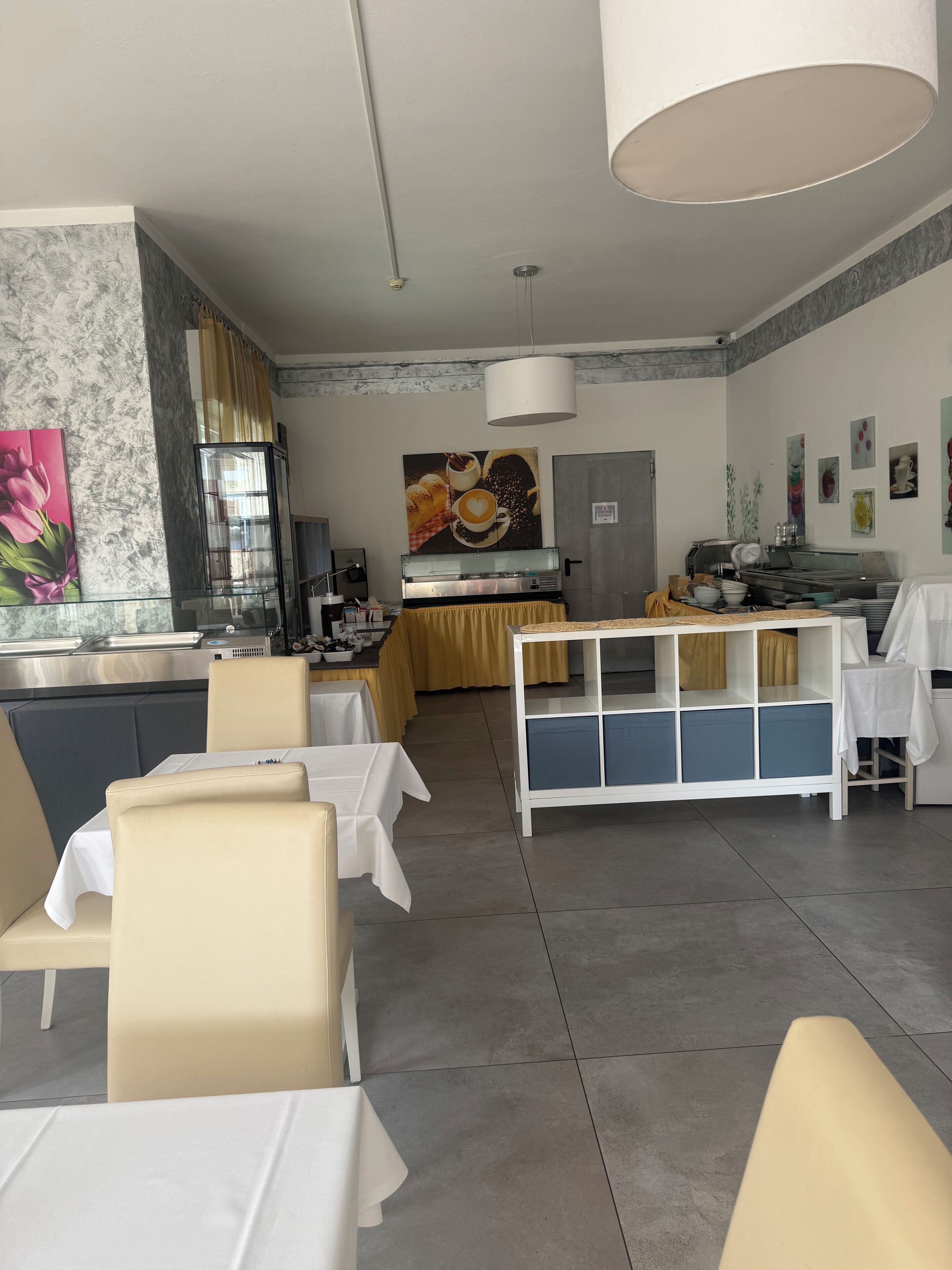 A modern dining area with a central counter, seating, and a kitchen in the background.