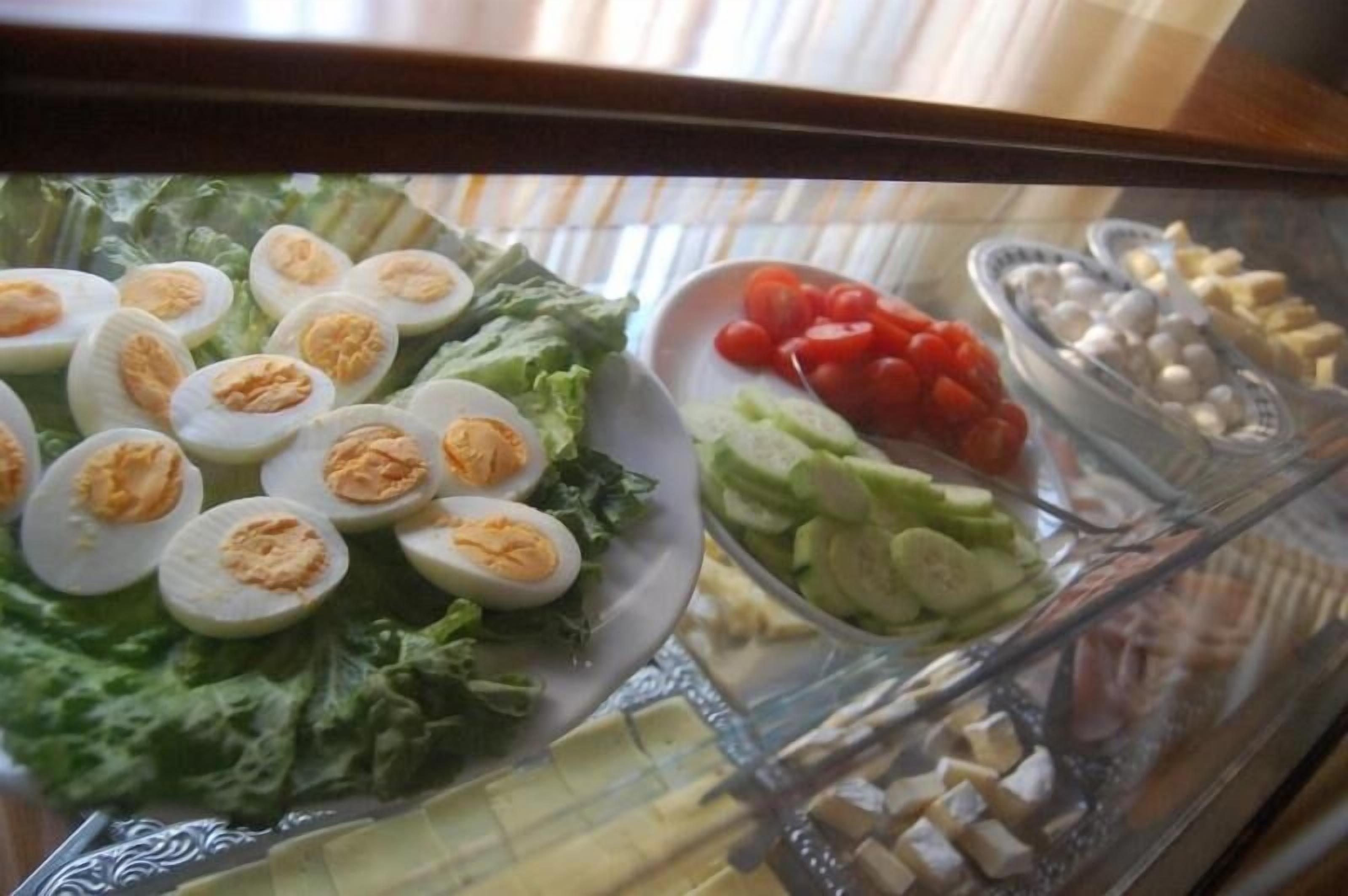 Un buffet de salades proposant une variété de légumes et des œufs durs coupés en tranches.