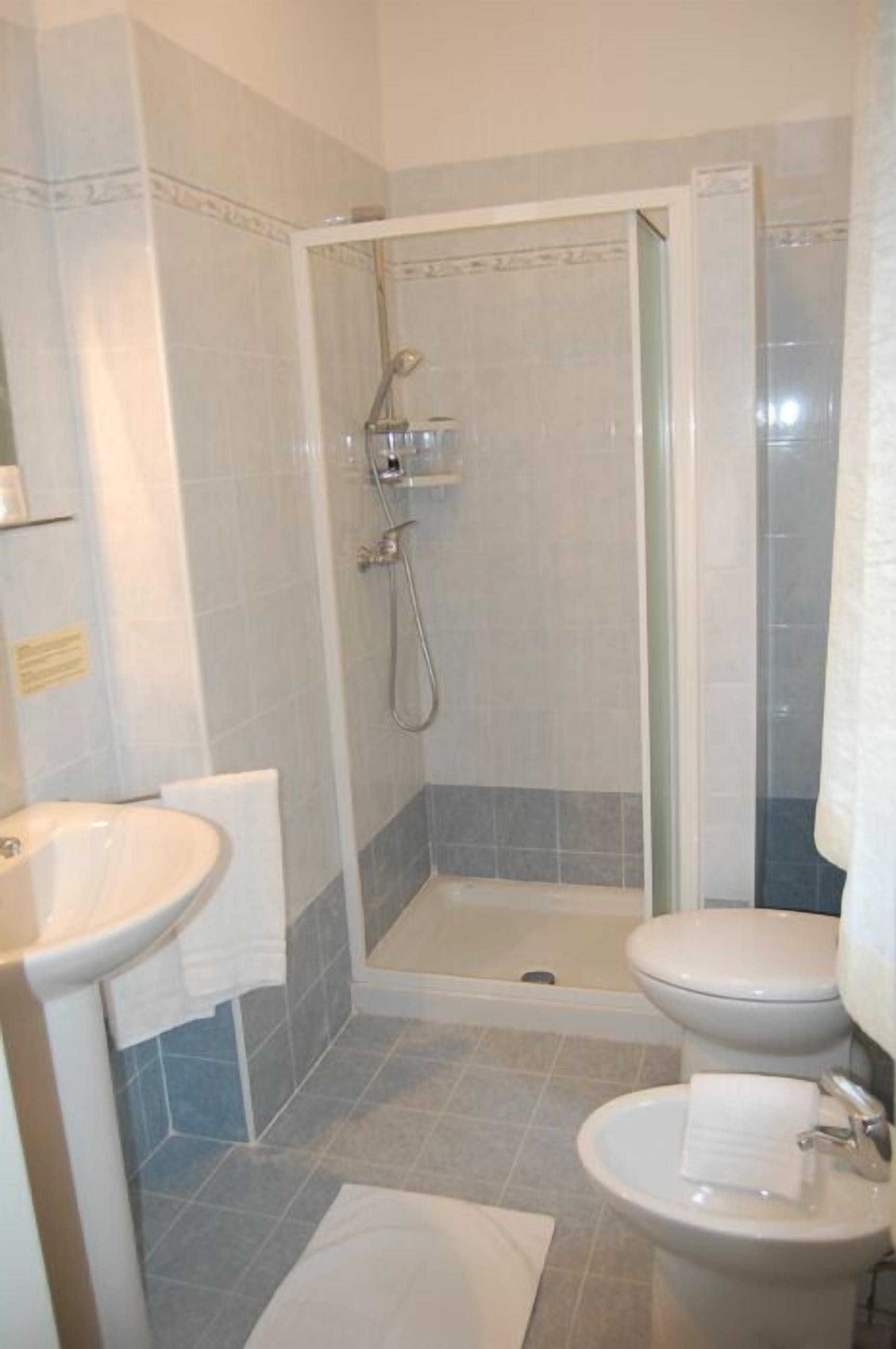 Ein Badezimmer mit Dusche, Waschbecken und Toilette.
