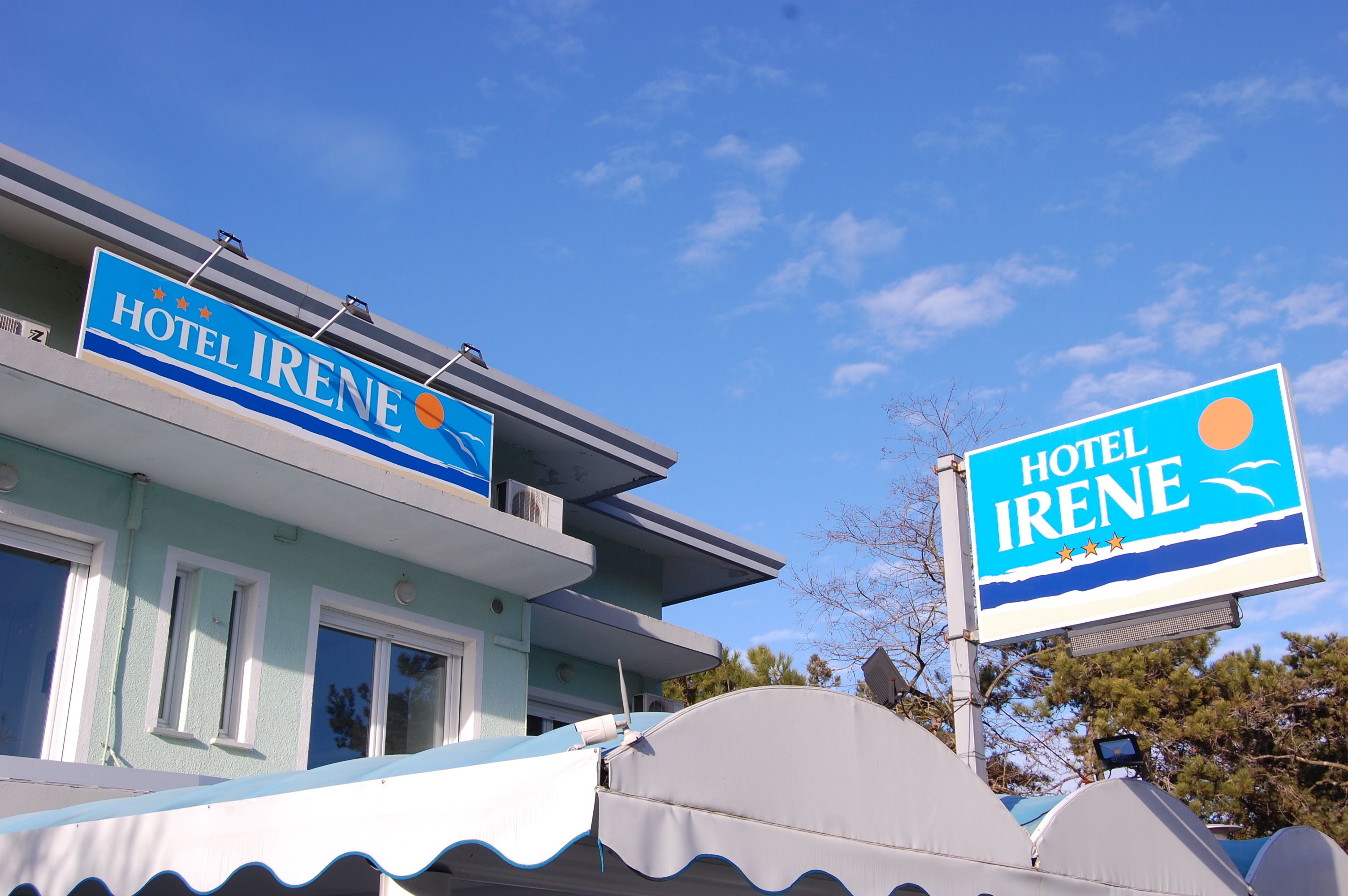 Ein Hotel namens 'Hotel Irene' mit blauem Himmel und einem Schild.