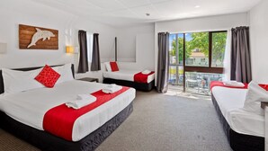 Ein Hotelzimmer mit zwei Betten, einem Balkon mit Blick und einem Holzbilde.
