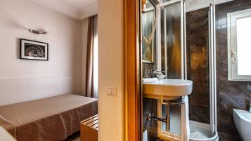 Un baño moderno con cabina de ducha de vidrio, lavamanos y retrete.