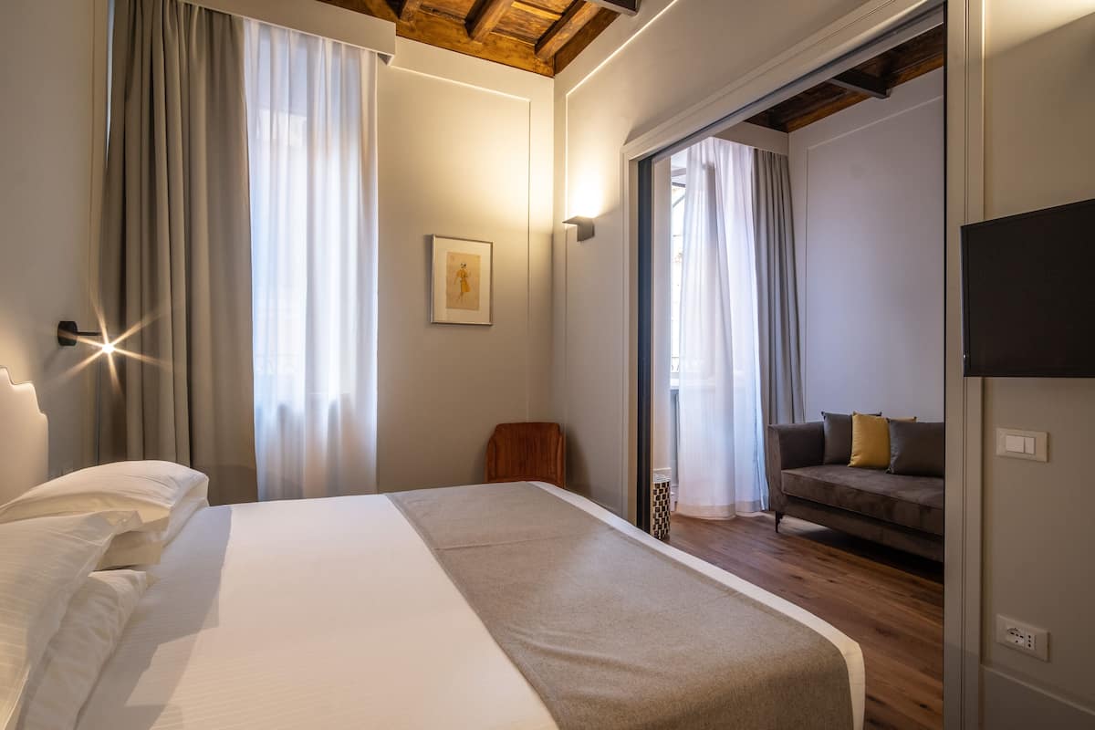 Une chambre à coucher avec un lit, un canapé et une télévision.