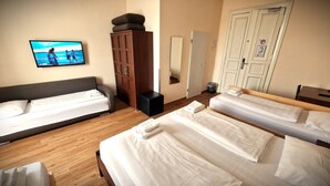 A hotel room with two single beds, a wooden cabinet, a television displaying a beach scene, and a mirror. - Mikon Eastgate Hotel (Berlin)