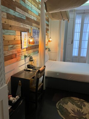 A bedroom with a wooden wall, a bed, a desk with a telephone, and a chair. - Hotel Life Gran Via (Madrid)
