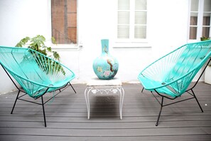 Two turquoise chairs on a wooden deck with a white table and a vase between them. - Hotel Life Gran Via (Madrid)
