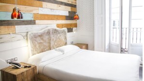 A neatly made bed with white linens, a woven headboard, and two bedside lamps. - Hotel Life Gran Via (Madrid)