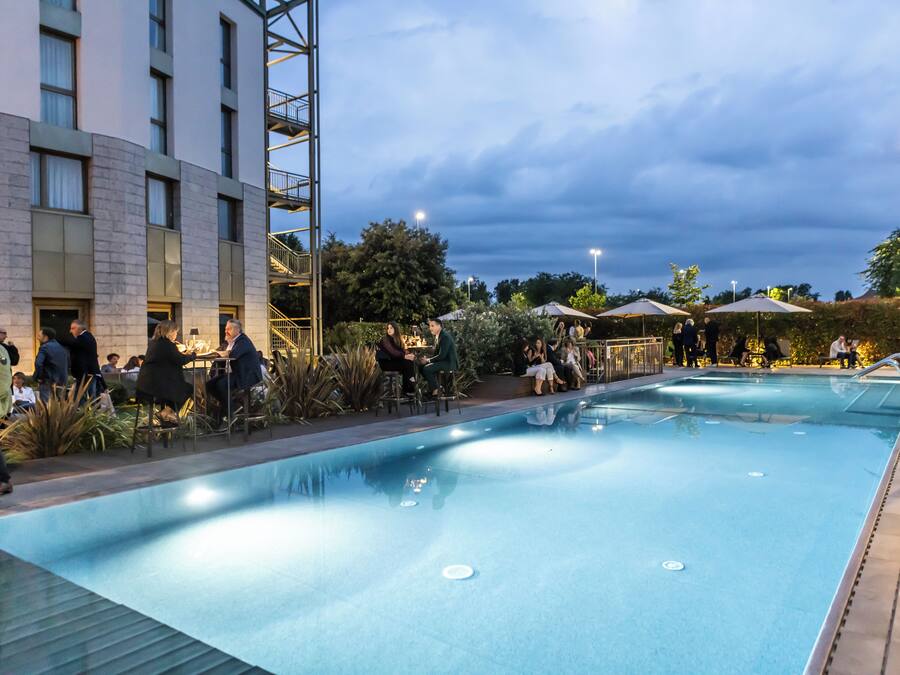 Una piscina techada, una piscina al aire libre de temporada, sombrillas