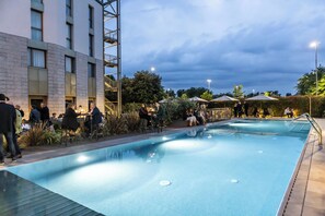 Una piscina techada, una piscina al aire libre de temporada, sombrillas