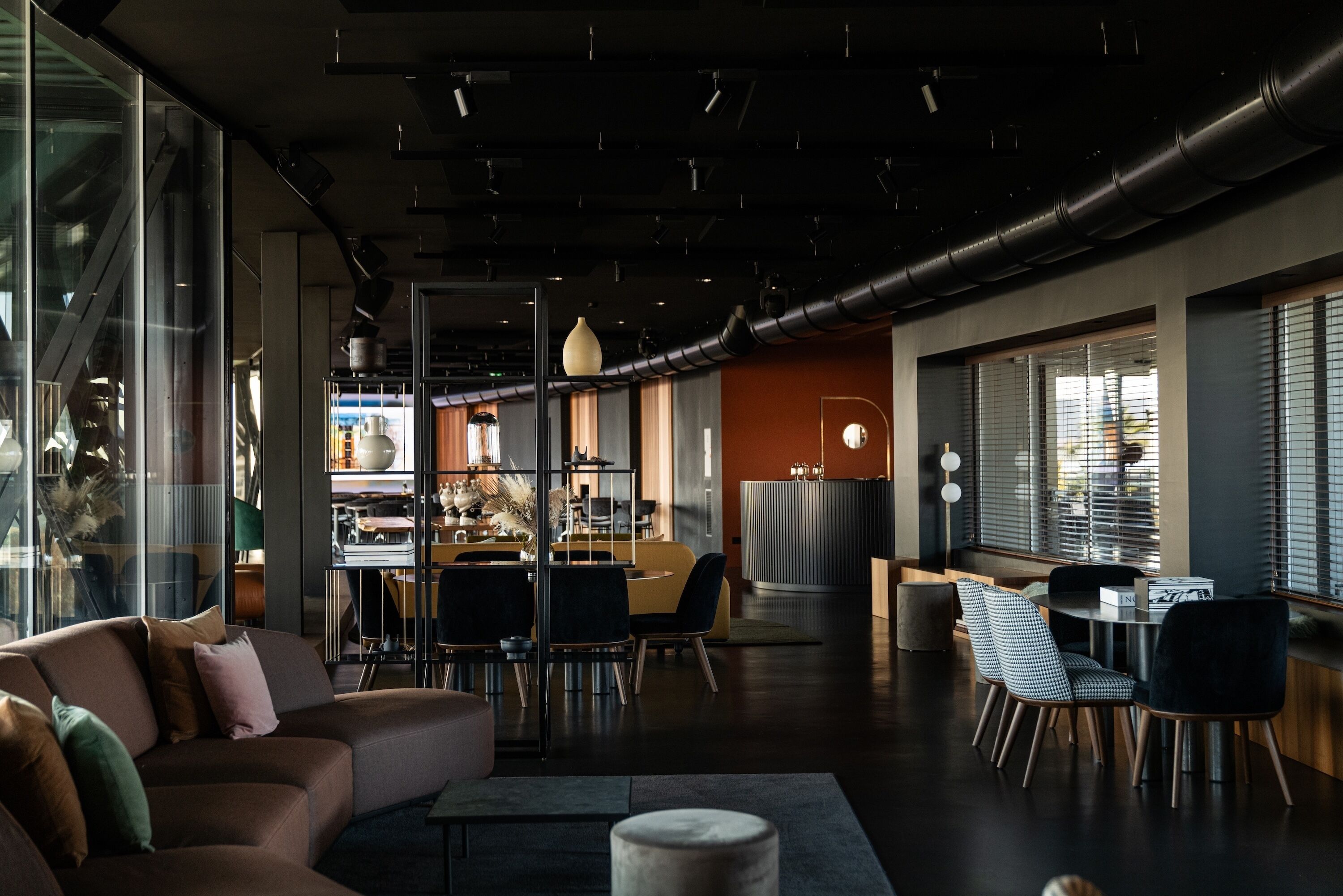 A modern interior with a sofa, dining area, and kitchen.