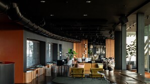 A modern interior with a curved reception desk, seating area with sofas and chairs, and large windows allowing natural light. - Litta Palace Milano Urban Resort (Lainate)