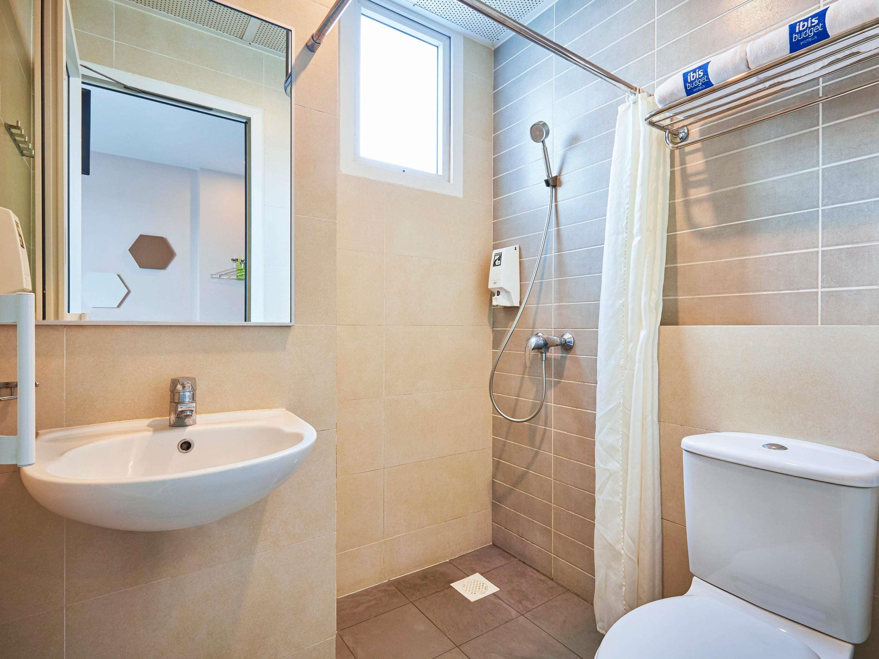 A bathroom with a sink, shower, and toilet.