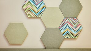 A wall with hexagonal tiles in various patterns and colors. - ibis budget Singapore Imperial (Singapore)