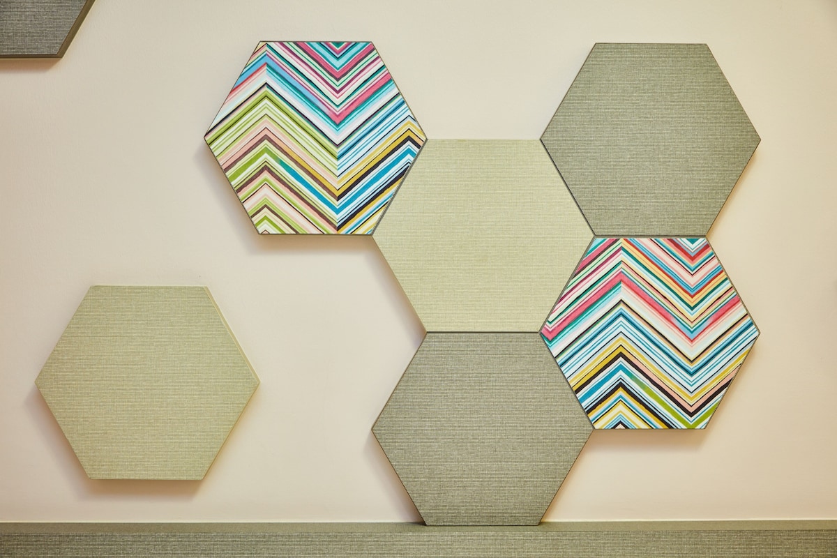 Una pared con baldosas hexagonales en diversos diseños y colores.