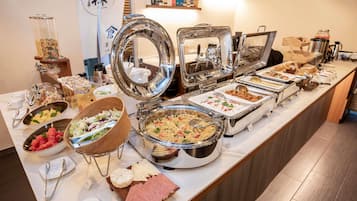 Un buffet proposant une variété de plats, notamment des salades, des viandes et des desserts.