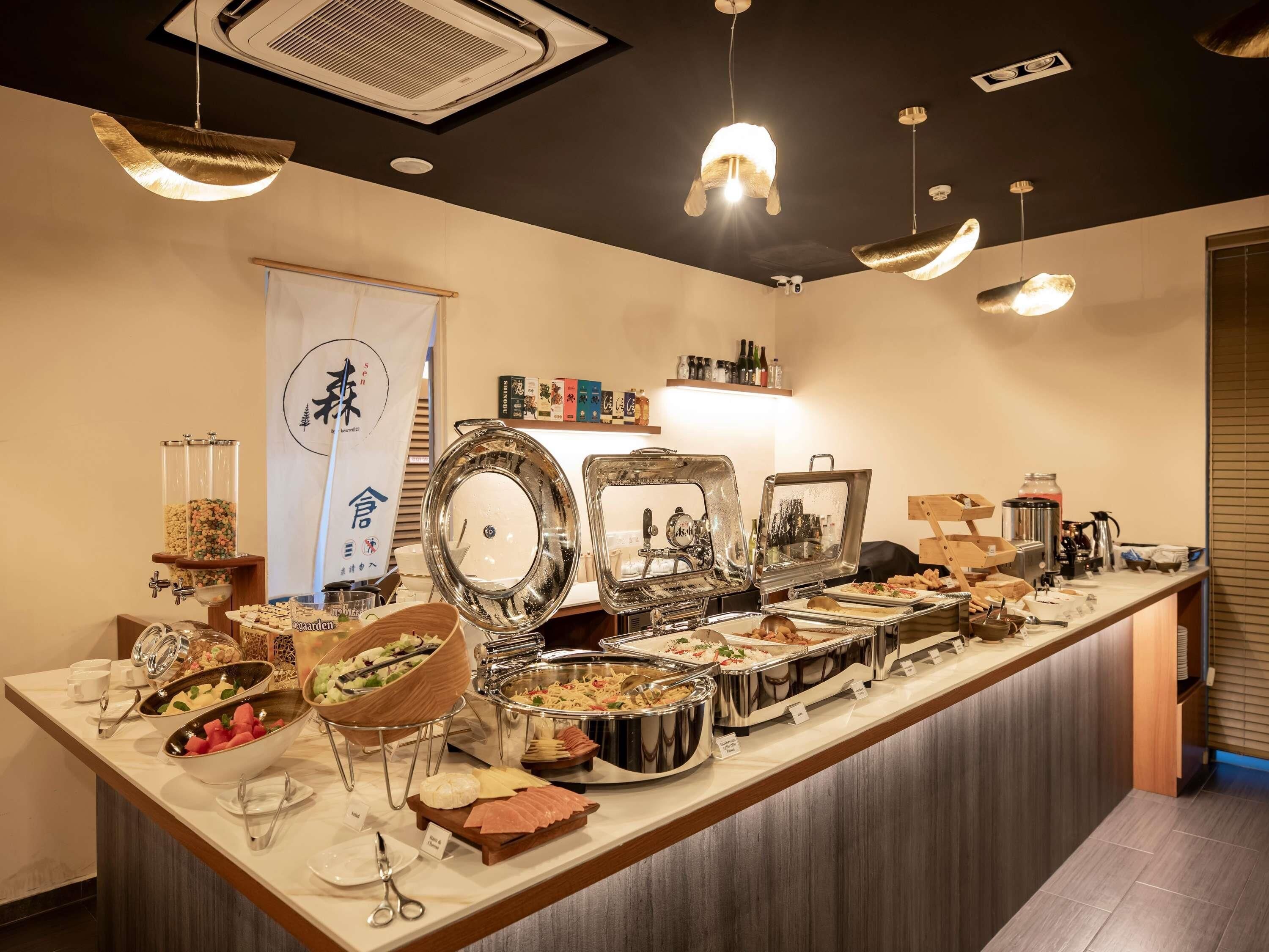 A buffet setup with various food items and utensils.