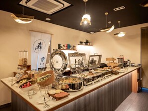 Una mesa de buffet con diversos alimentos y utensilios.
