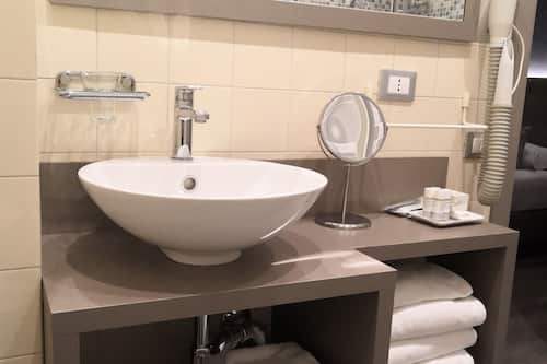 Habitación individual superior | Baño | Ducha, artículos de higiene personal gratuitos y secador de pelo