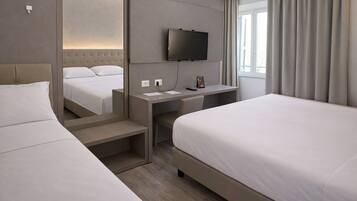 Een hotelkamer met twee bedden, een bureau, een flatscreen televisie, een spiegel en een raam met gordijnen.