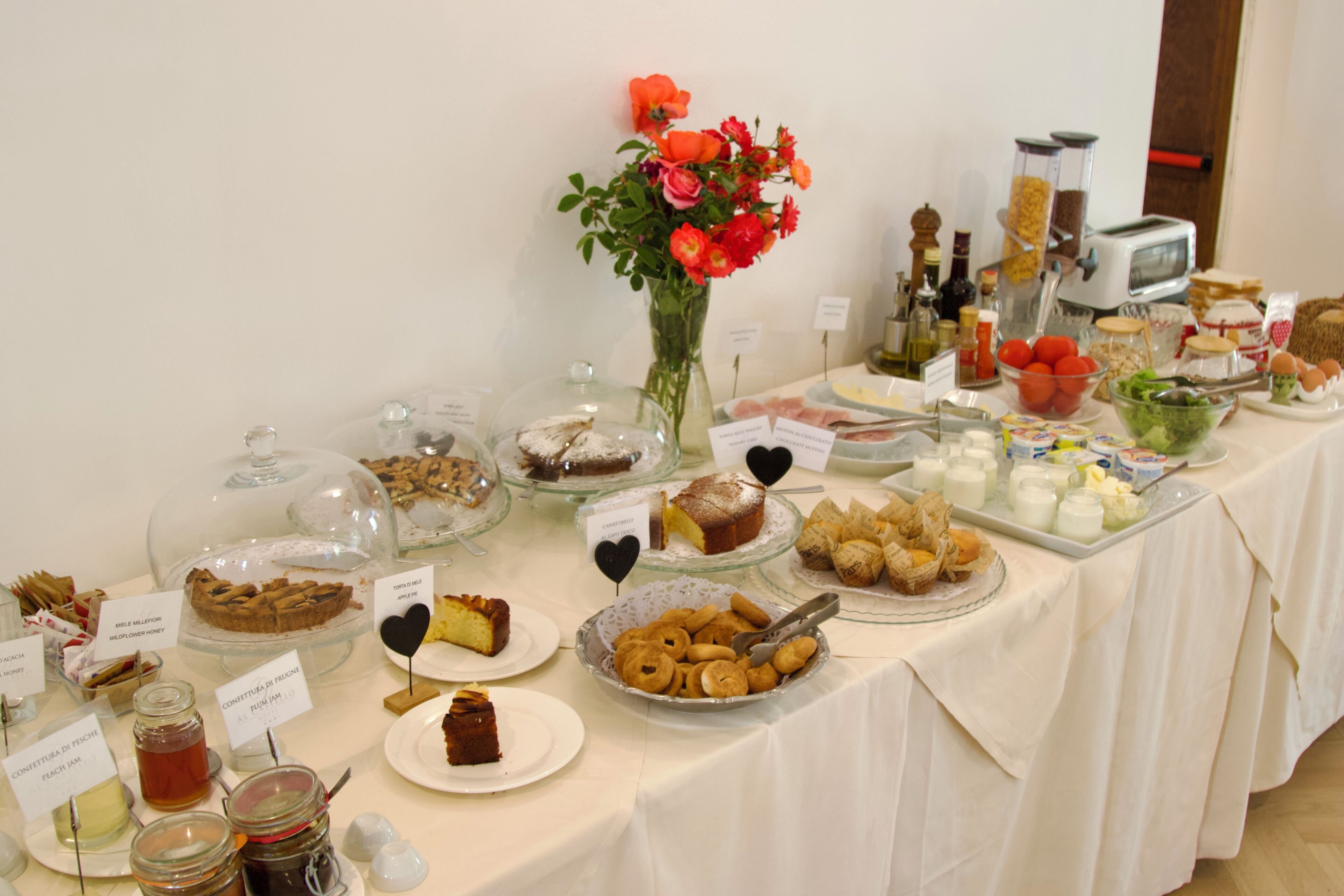 A buffet table with various food items and a vase of flowers.