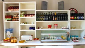 Un espace cuisine bien aménagé, avec des étagères remplies de divers produits alimentaires, d’épices et de boissons.
