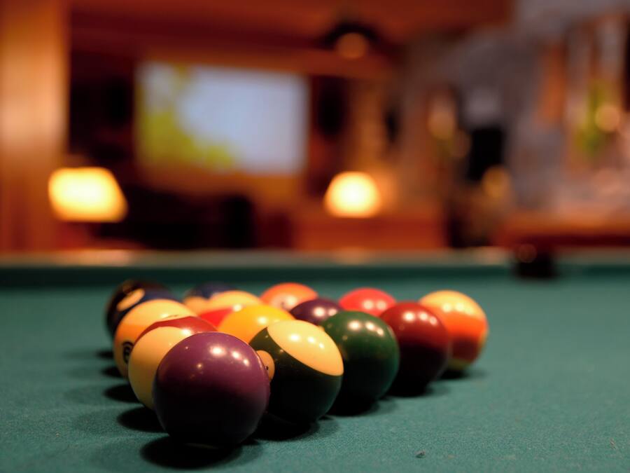 A pool table with a row of billiard balls.
