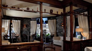 Un restaurante con pared de piedra, vigas de madera y una mesa blanca.