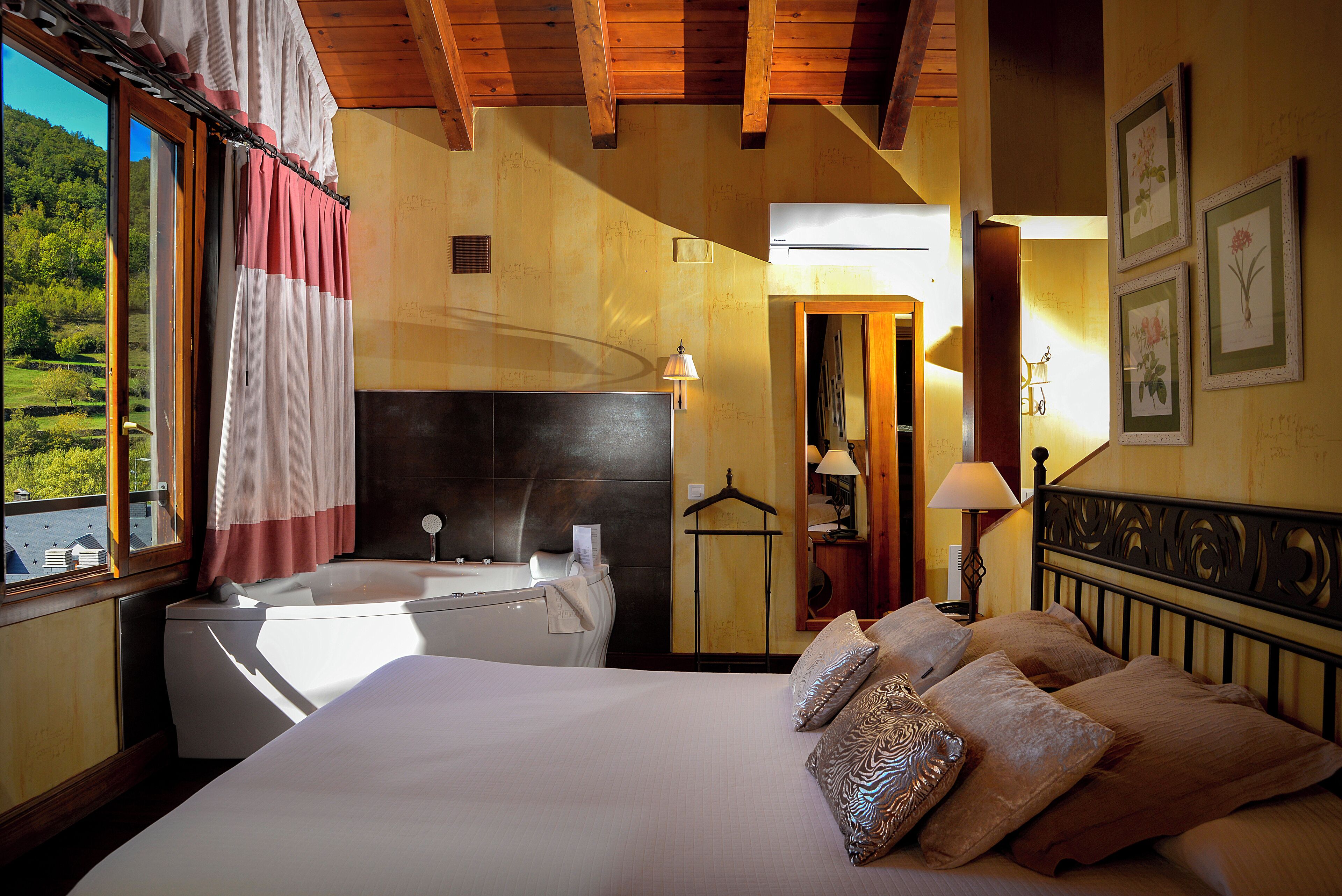 Un dormitorio con una cama grande, una bañera y vistas a zonas verdes.