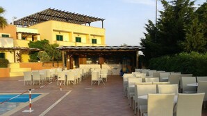 A poolside area with white wicker chairs and a covered seating area. - L'Arco del Saracino (Salve)