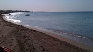 A beach with a boat in the water and footprints in the sand. - L'Arco del Saracino (Salve)