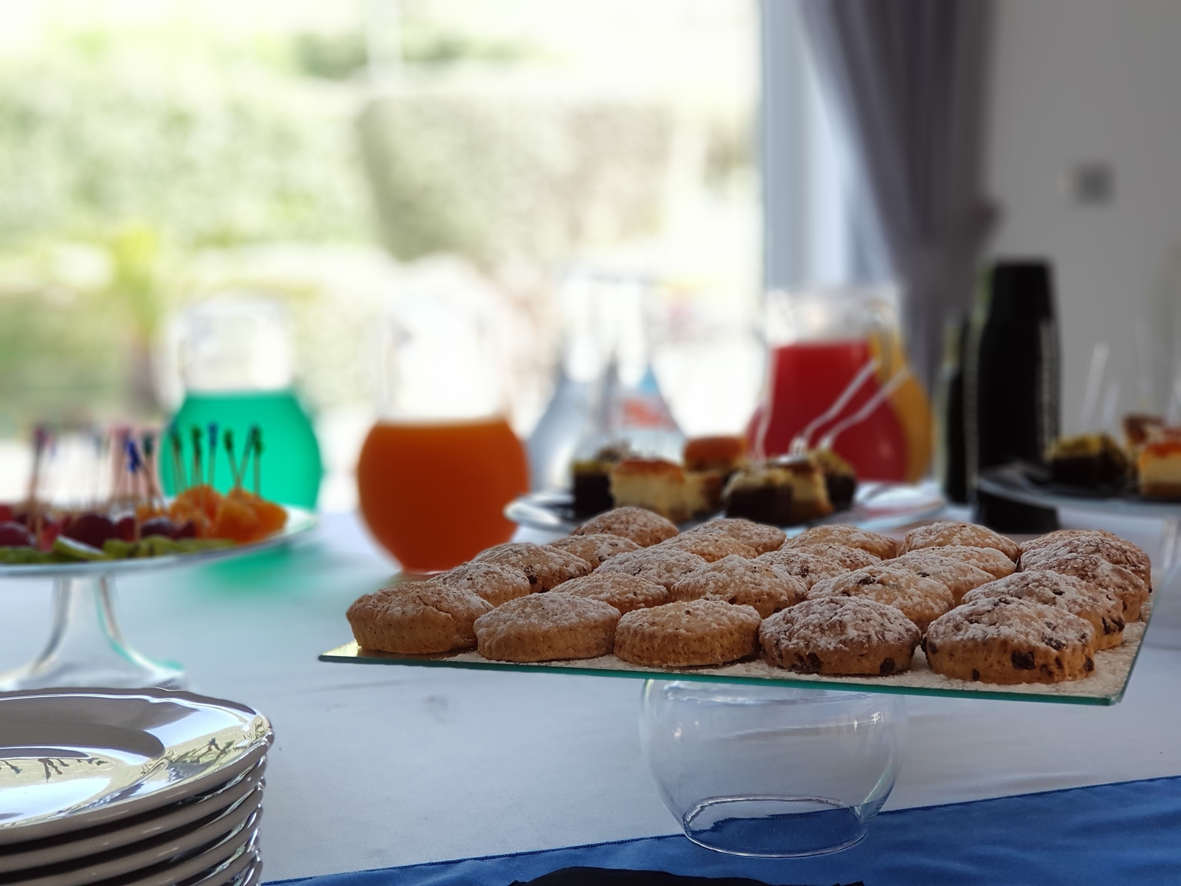 Un buffet per la colazione con diversi dolci e una caraffa di succo d'arancia.