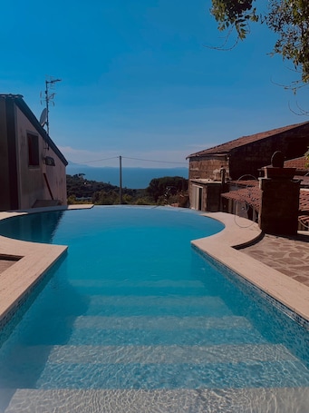 Una piscina al aire libre, sillones reclinables de piscina