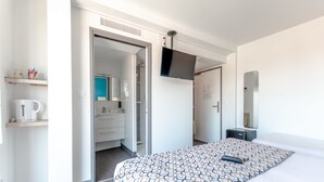 A hotel room with a bed, a TV mounted on the wall, a bathroom with a shower, and a small desk. - Sure Hotel by Best Western Saint-Raphael Le Dramont (Saint-Raphael)