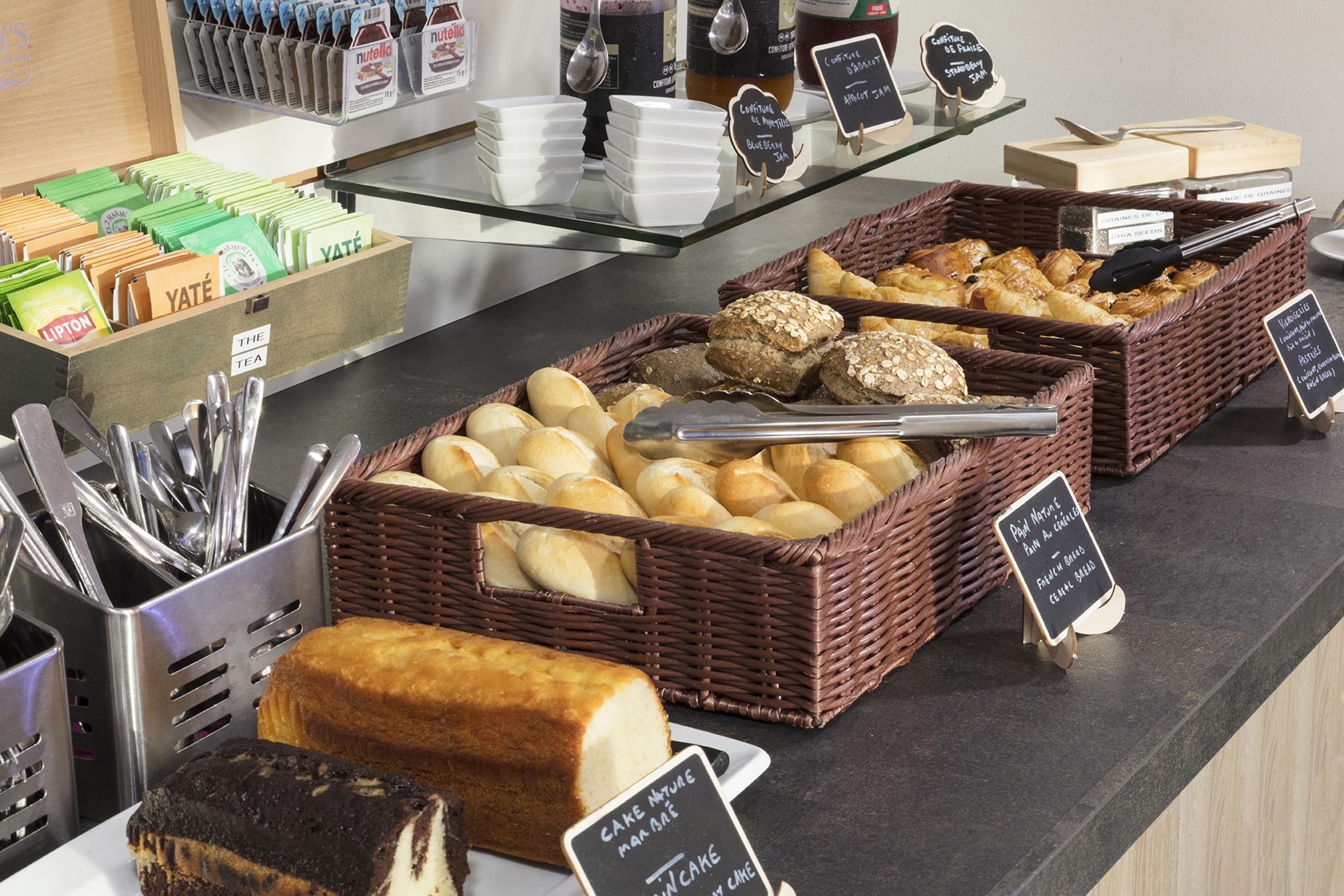 Un présentoir de boulangerie avec divers produits de pâtisserie et un coin pour préparer le thé.
