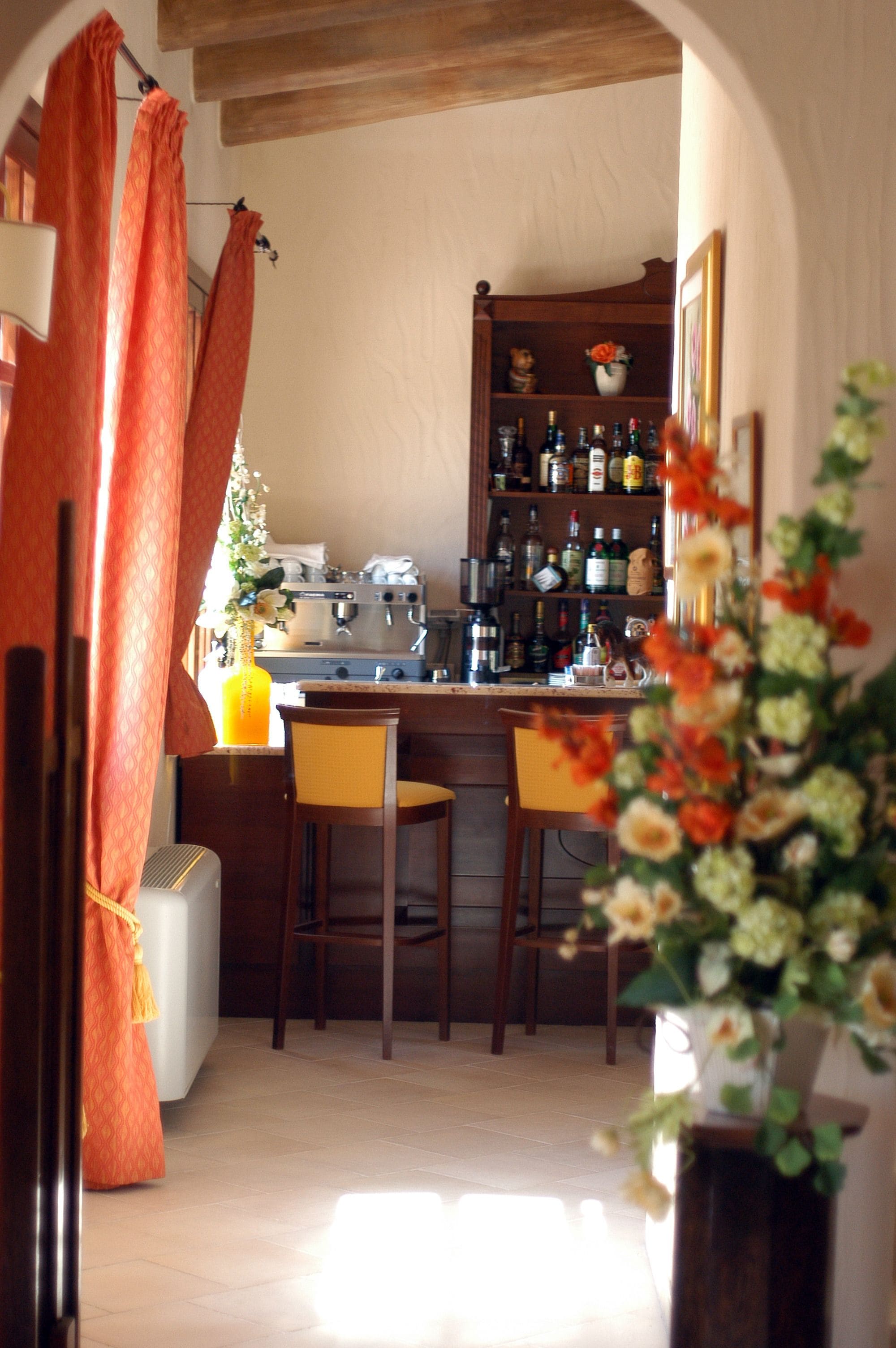 A kitchen with a bar area, wooden cabinets, and a dining table with chairs.
