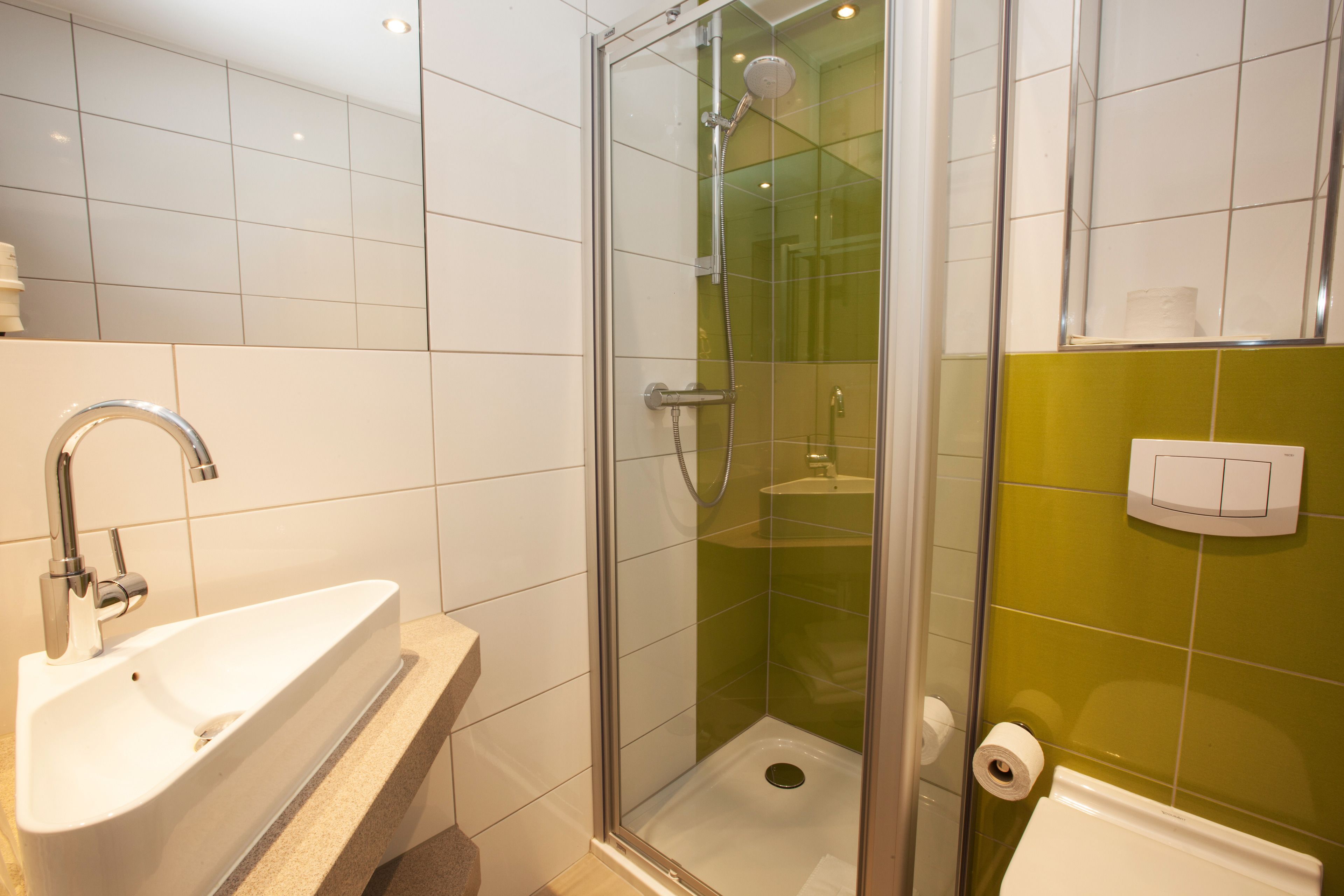 Un bagno con doccia vetrata, lavandino e WC.
