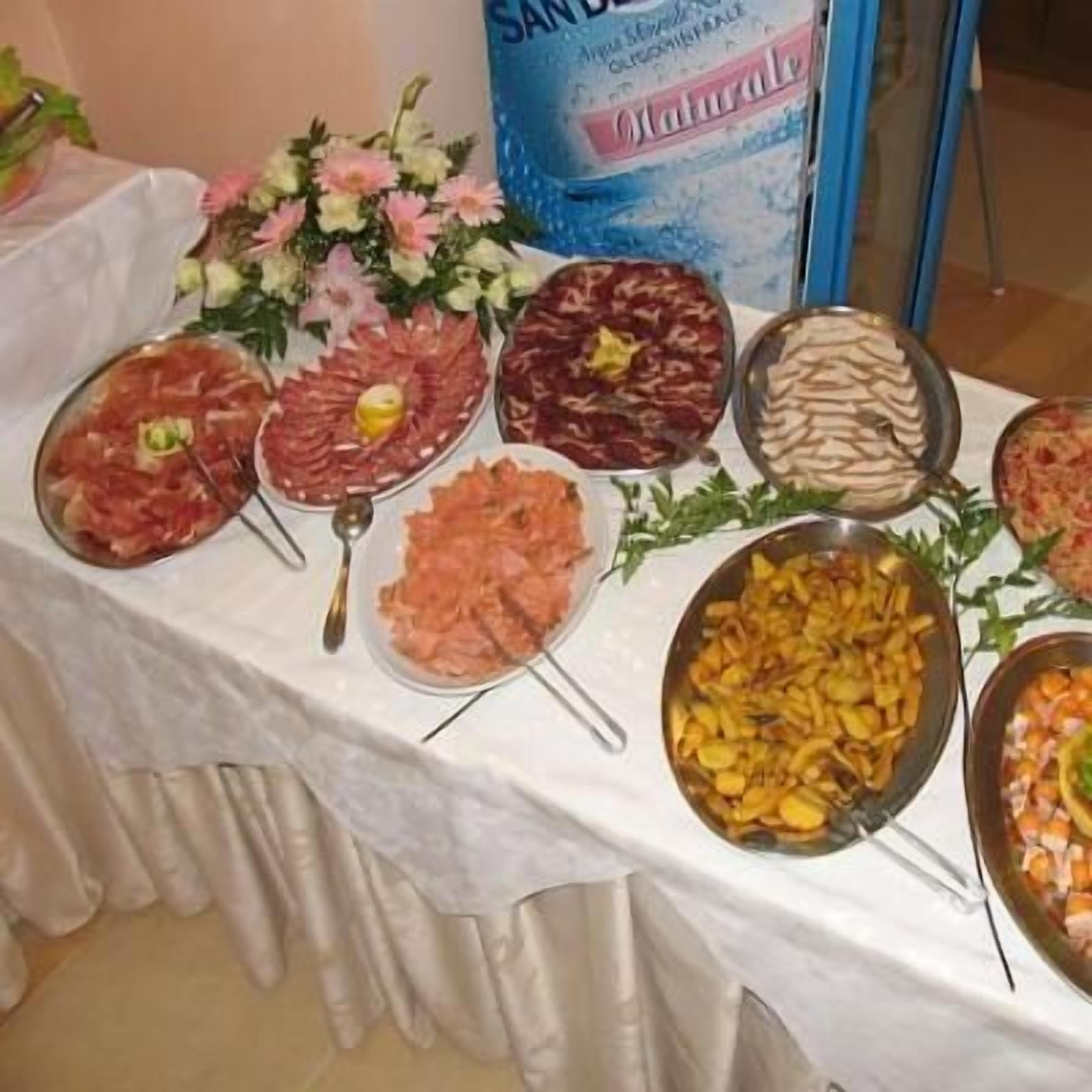 Ein reichhaltiges Buffet mit verschiedenen Speisen, darunter Fleisch, Käse und Obst.