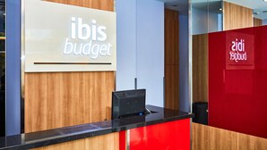 Ein Empfangstresen mit einem Schild, auf dem 'ibis budget' steht.