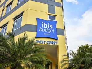 A building with a sign for ibis budget hotels. - ibis budget Singapore West Coast (Singapore)