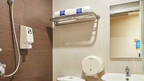 A modern bathroom with a toilet, bidet, and sink. - ibis budget Singapore West Coast (Singapore)