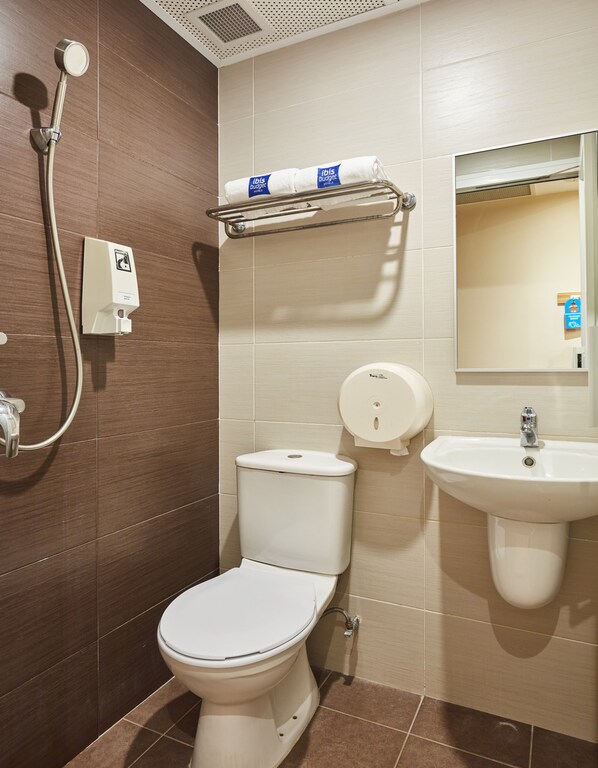 Une salle de bain moderne équipée de toilettes, d’un bidet et d’un lavabo.