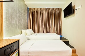 A hotel room with a bed, a television mounted on the wall, and a microwave on a wooden counter. - ibis budget Singapore West Coast (Singapore)