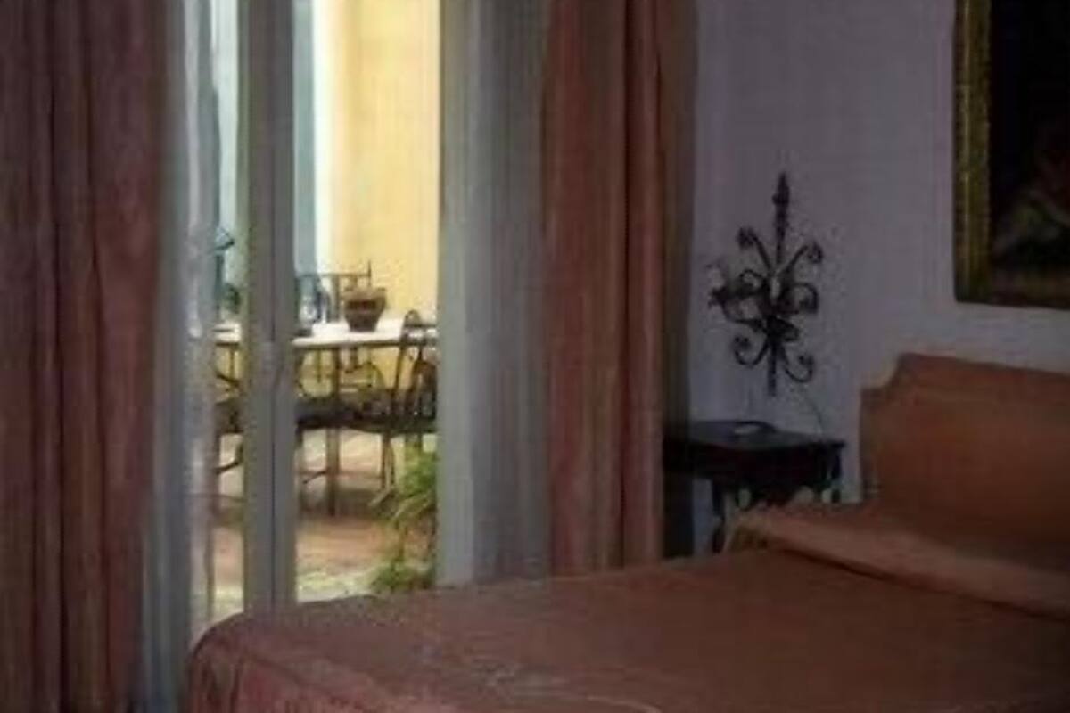 A bedroom with a bed, a small table, and a chair.