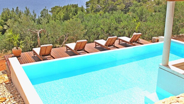 A pool with lounge chairs and a view of the sea. - Villa Perka (Hvar)